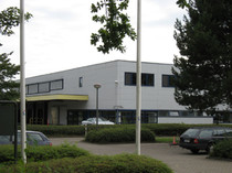 Parkplatz mit weißem Gebäude im Hintergrund